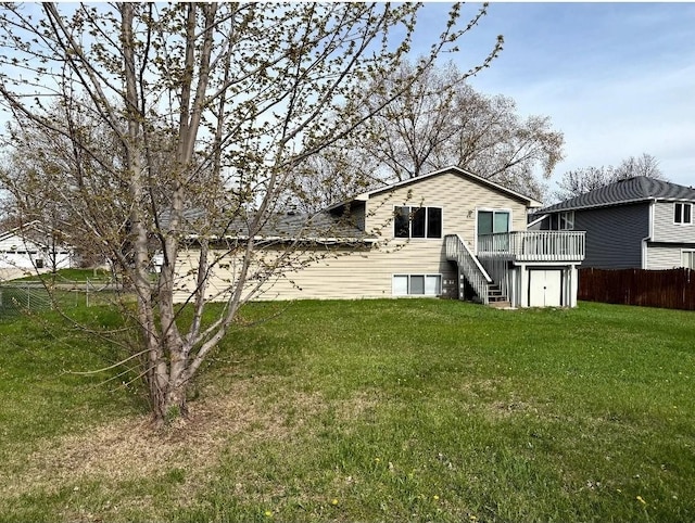 9007 Hampshire Ave N, Brooklyn Park, MN 55445 - rear view of property featuring fence, a yard, stairway, and a deck