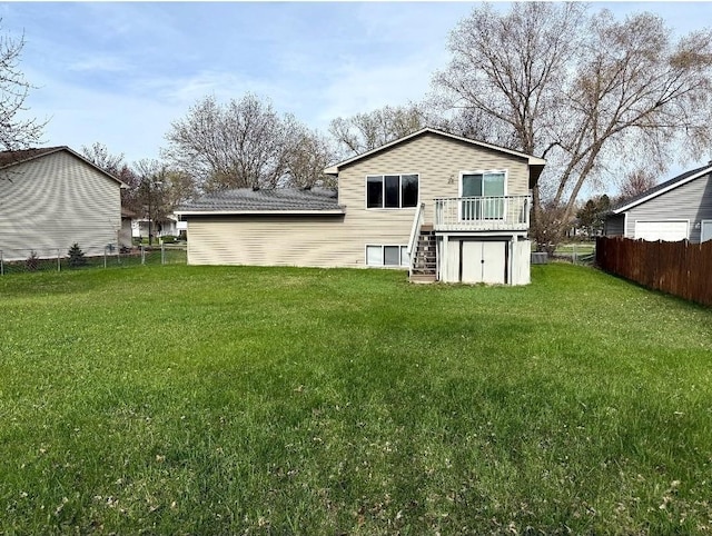 9007 Hampshire Ave N, Brooklyn Park, MN 55445 - rear view of house with fence, a yard, stairway, and a deck