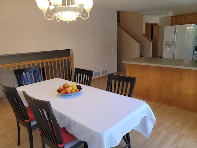 44 Willow Way, Farmington, MN 55024 - dining space with light wood-type flooring, a chandelier, and stairway