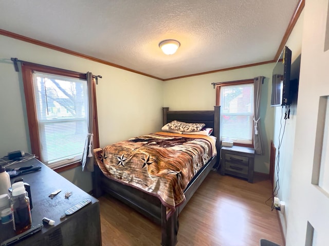 bedroom featuring crown molding, a textured ceiling, and wood finished floors