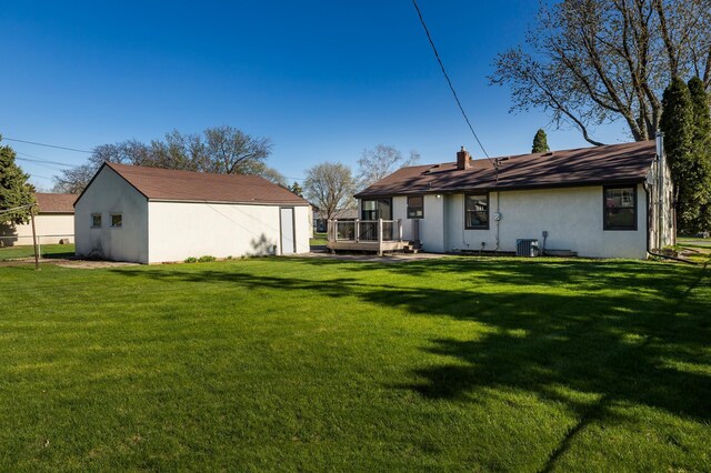 back of house with a lawn, stucco siding, a deck, and cooling unit