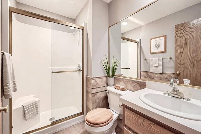 16439 Tippecanoe St NE, Ham Lake, MN 55304 - bathroom featuring vanity, toilet, a stall shower, tile patterned floors, and tile walls
