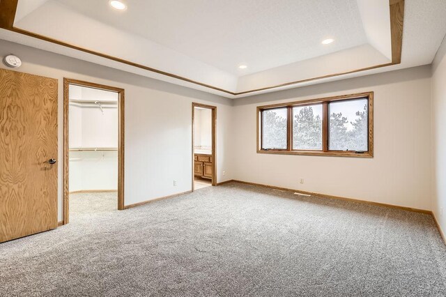 16439 Tippecanoe St NE, Ham Lake, MN 55304 - unfurnished bedroom with a raised ceiling, baseboards, carpet floors, recessed lighting, and a walk in closet