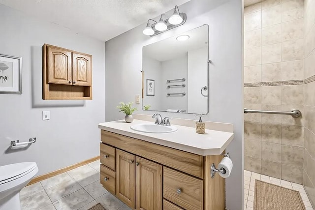 16439 Tippecanoe St NE, Ham Lake, MN 55304 - bathroom featuring tile patterned flooring, vanity, toilet, baseboards, and tiled shower