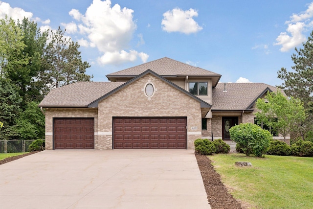 16439 Tippecanoe St NE, Ham Lake, MN 55304 - view of front of home with brick siding, driveway, an attached garage, and roof with shingles
