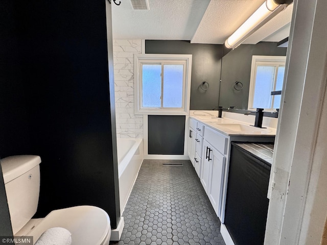 full bath featuring a sink, double vanity, toilet, a textured ceiling, and visible vents