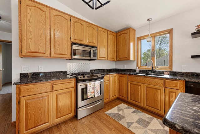 8370 Hamel Way, Morristown, MN 55052 - kitchen with appliances with stainless steel finishes, a sink, light wood-style flooring, hanging light fixtures, and dark stone counters