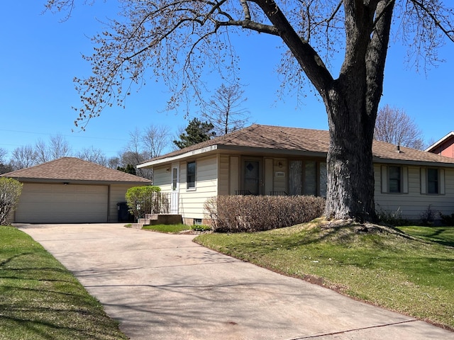 ranch-style home with a detached garage, an outbuilding, and a front lawn