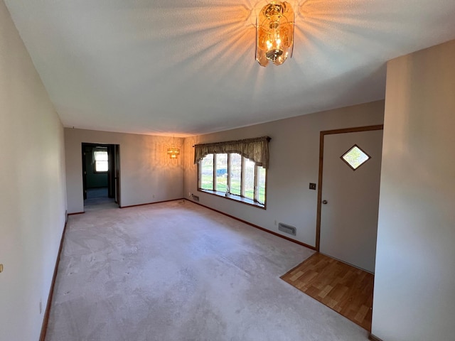 entrance foyer with light colored carpet, baseboards, and visible vents