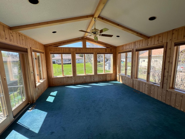 unfurnished sunroom featuring wood walls, lofted ceiling with beams, and a wealth of natural light