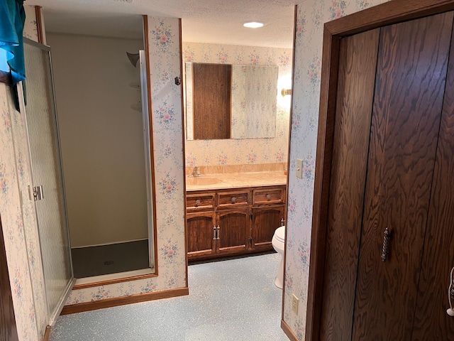 full bathroom with vanity, baseboards, a shower stall, and wallpapered walls