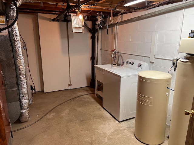 laundry area featuring concrete block wall, laundry area, and washer / clothes dryer