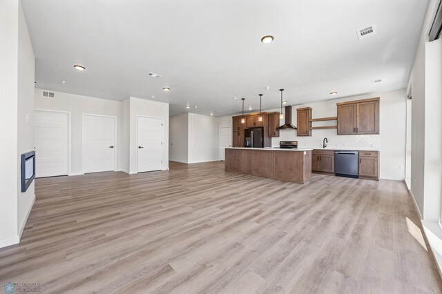 kitchen featuring open floor plan, black fridge, wall chimney exhaust hood, and dishwasher