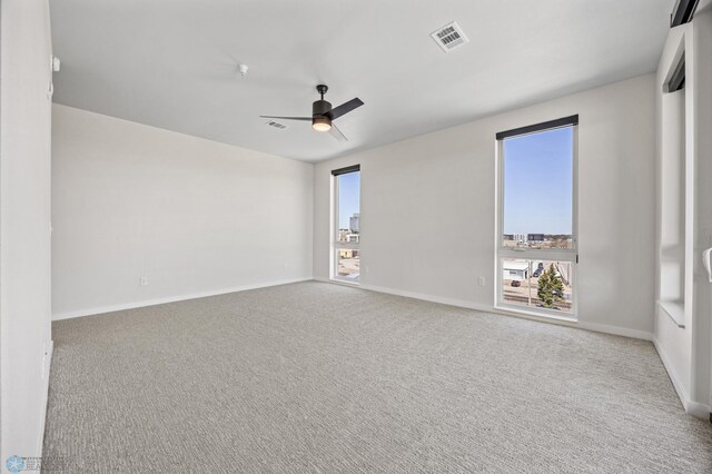 unfurnished room with carpet floors, ceiling fan, plenty of natural light, and baseboards
