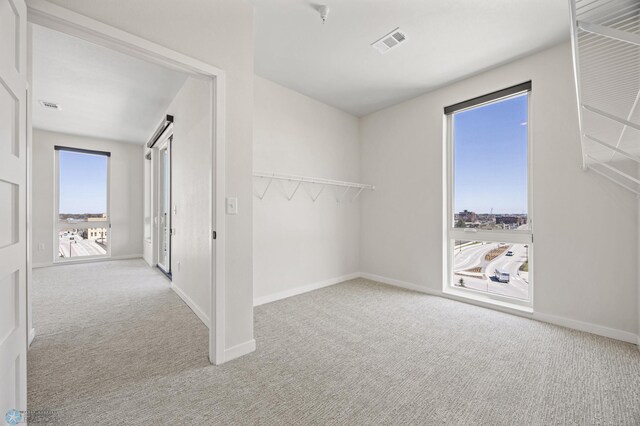 unfurnished bedroom with baseboards, carpet flooring, and visible vents
