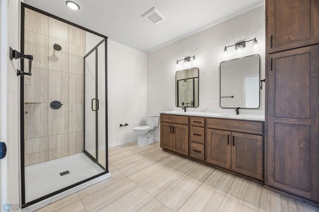 bathroom featuring visible vents, double vanity, toilet, baseboards, and a stall shower