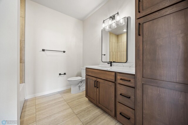 full bath with vanity, baseboards, and toilet