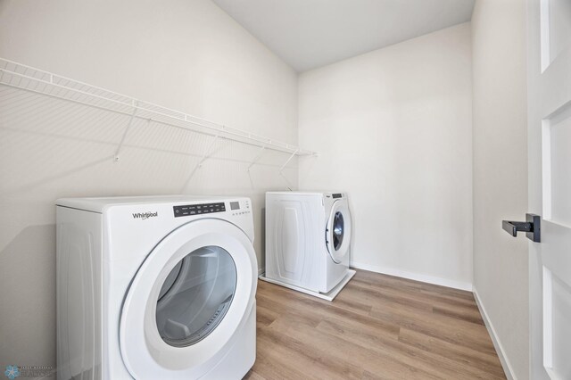 washroom with baseboards, laundry area, light wood finished floors, and independent washer and dryer