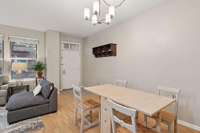 dining area featuring baseboards, a notable chandelier, and light wood-style floors