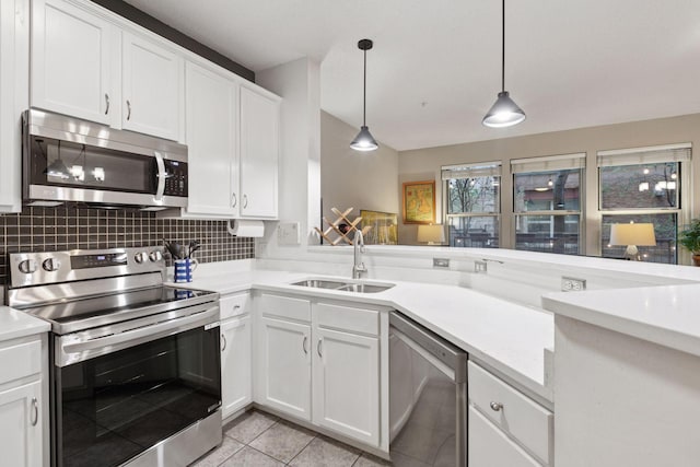kitchen featuring decorative backsplash, light countertops, white cabinetry, a sink, and appliances with stainless steel finishes