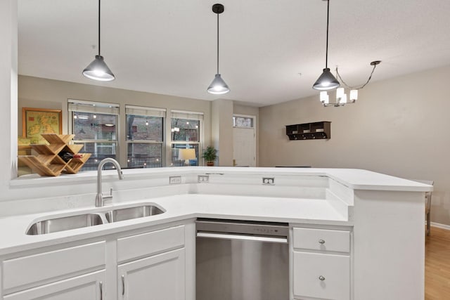 kitchen with a sink, light countertops, stainless steel dishwasher, and white cabinetry