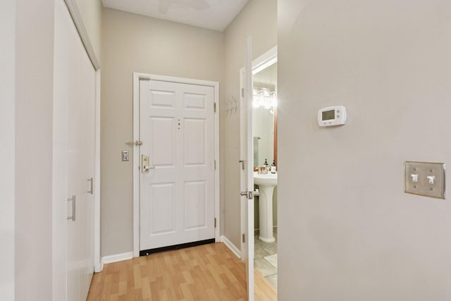 doorway with baseboards and light wood finished floors