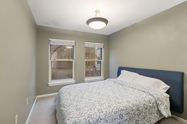 bedroom with baseboards, carpet flooring, and a textured ceiling
