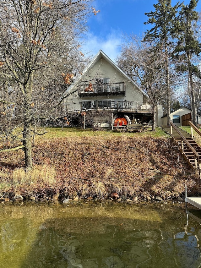 back of property with a deck and stairs