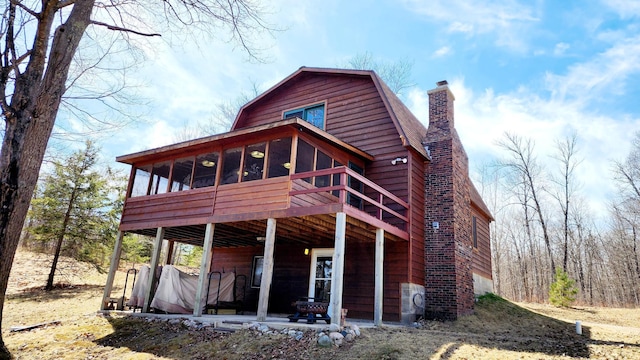 back of house with a deck and a chimney