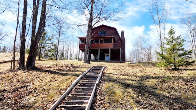 view of front facade with a chimney and stairway