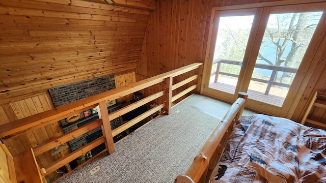 bedroom featuring wooden walls and access to exterior