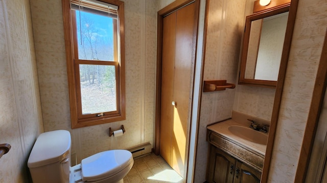 half bath featuring a baseboard heating unit, a wealth of natural light, toilet, and wallpapered walls