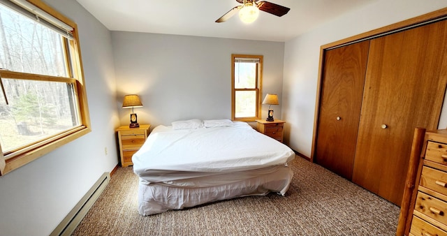 carpeted bedroom featuring a baseboard radiator, a closet, and ceiling fan