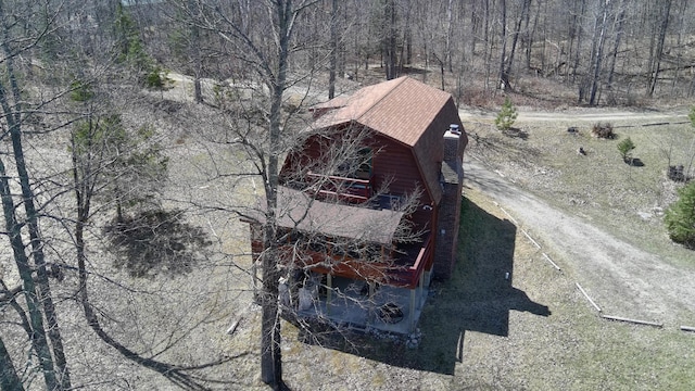 drone / aerial view featuring a wooded view