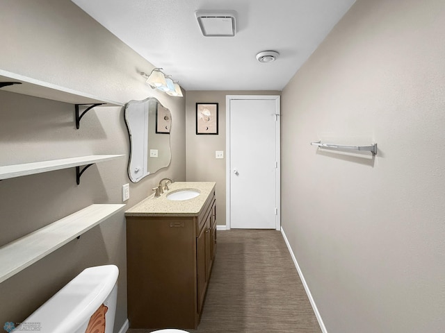 bathroom with baseboards, toilet, and vanity