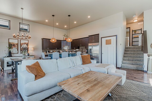 living area with recessed lighting, stairs, dark wood-style floors, and a notable chandelier