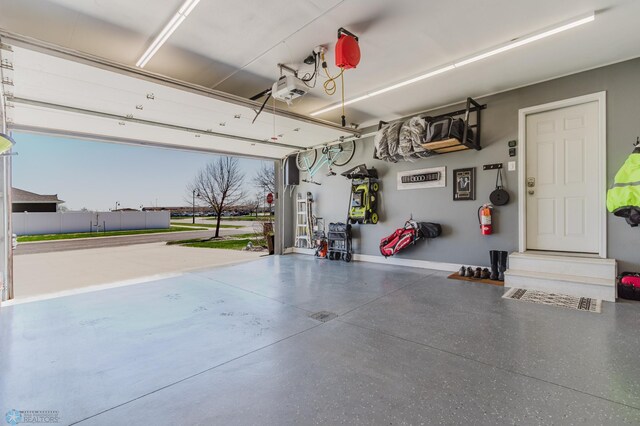 garage with baseboards and a garage door opener