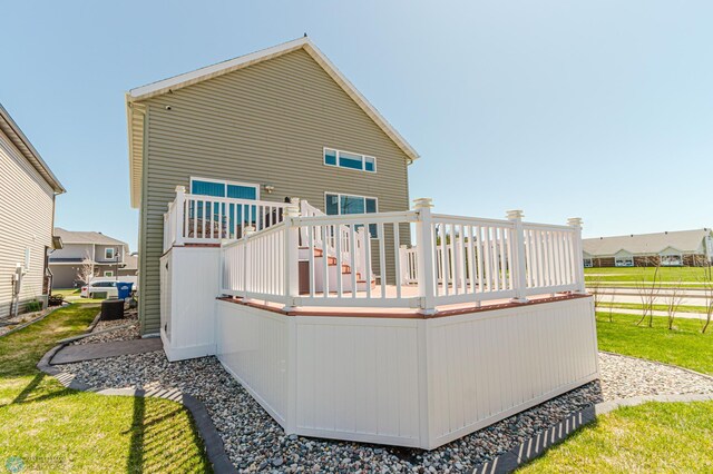 back of property featuring a lawn and a wooden deck
