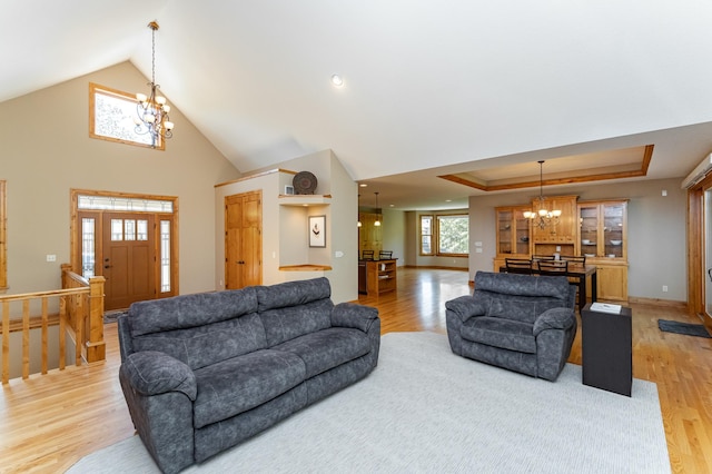 1315 Wicklow Ln SW, Rochester, MN 55902 - living area featuring a chandelier, light wood-style flooring, a tray ceiling, baseboards, and high vaulted ceiling