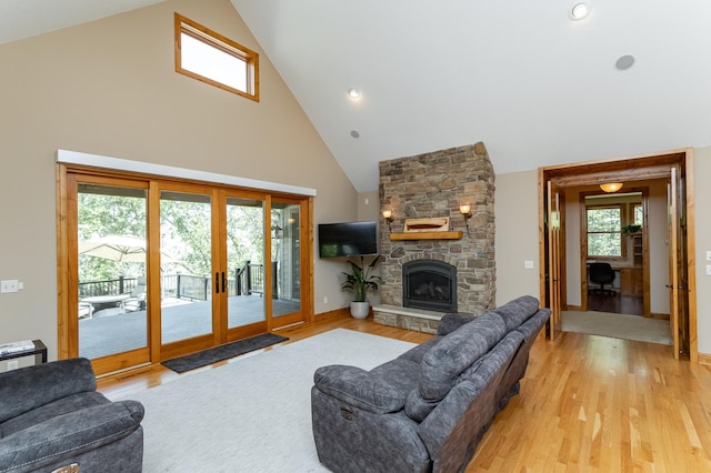 1315 Wicklow Ln SW, Rochester, MN 55902 - living room with high vaulted ceiling, french doors, light wood-style flooring, a stone fireplace, and baseboards