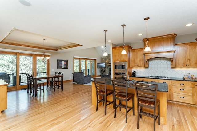 1315 Wicklow Ln SW, Rochester, MN 55902 - kitchen with appliances with stainless steel finishes, decorative backsplash, light wood-style floors, dark countertops, and a raised ceiling