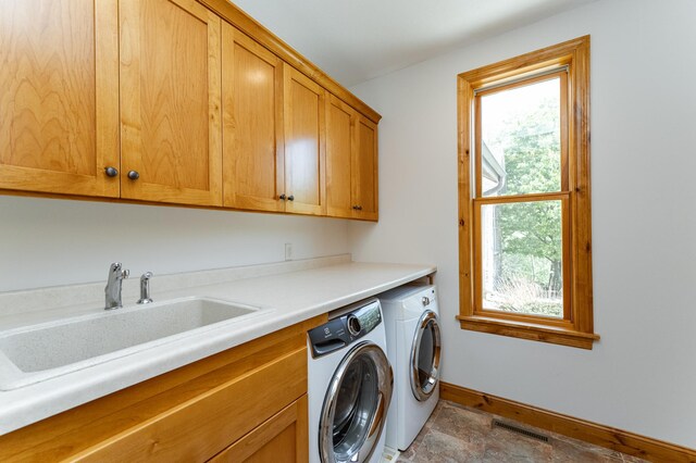 1315 Wicklow Ln SW, Rochester, MN 55902 - washroom featuring cabinet space, separate washer and dryer, baseboards, and stone finish floors