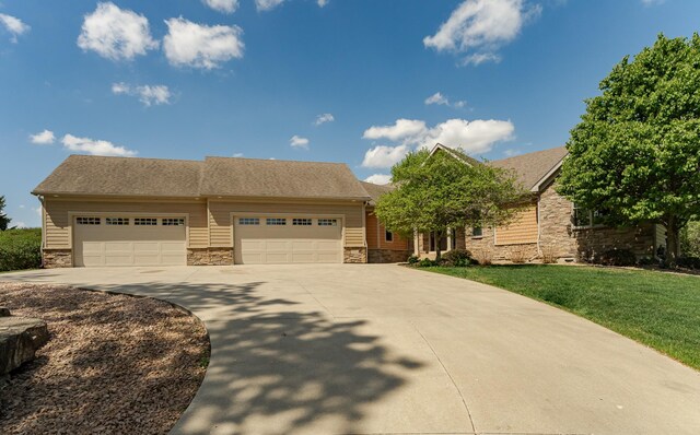 1315 Wicklow Ln SW, Rochester, MN 55902 - view of front of house featuring stone siding, concrete driveway, a garage, and a front yard