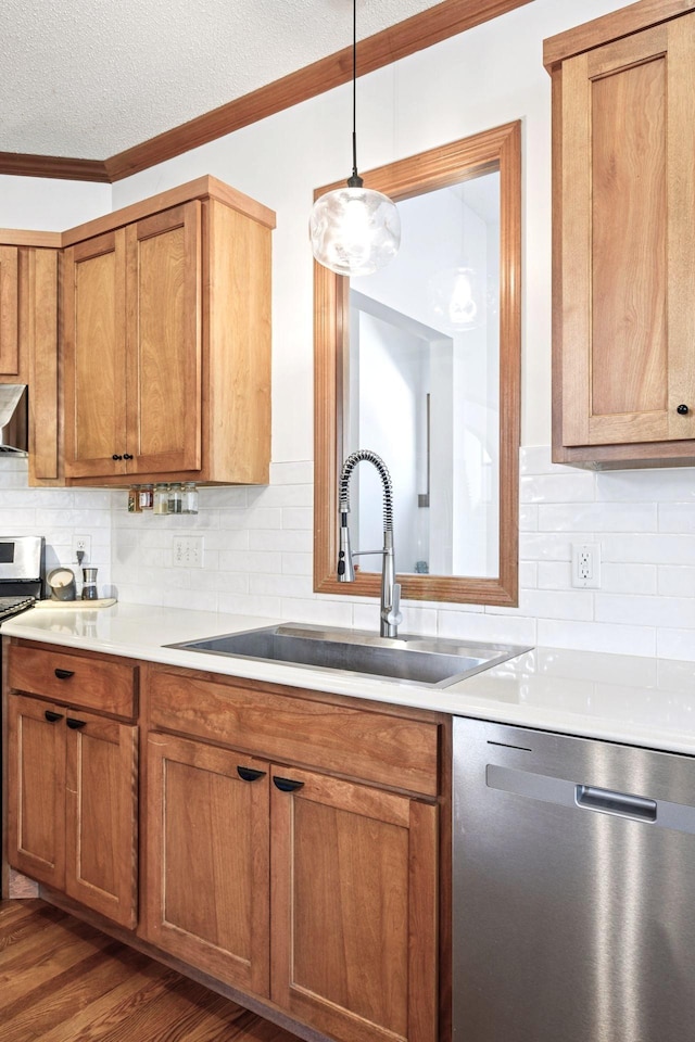kitchen featuring crown molding, stainless steel appliances, brown cabinets, and a sink