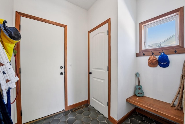 foyer entrance with dark tile patterned flooring and baseboards
