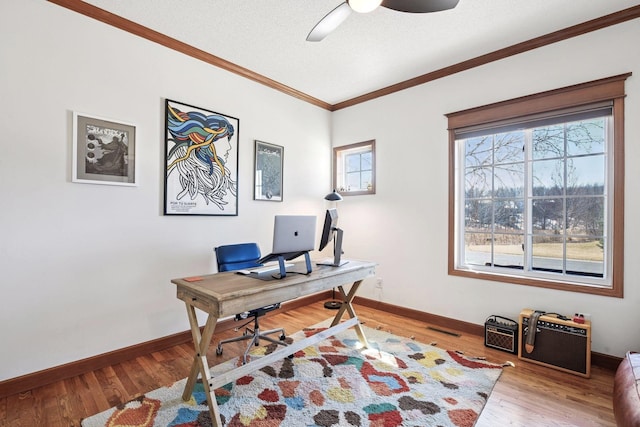 office area featuring light wood-style floors, baseboards, ornamental molding, and a ceiling fan