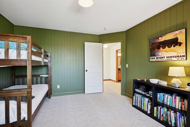 bedroom with wooden walls, baseboards, and carpet