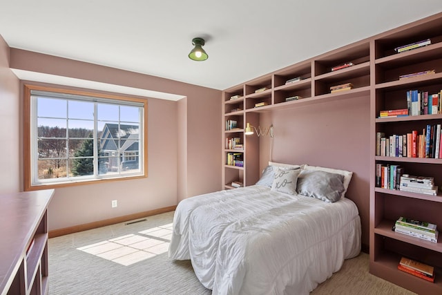 bedroom with baseboards, visible vents, and light carpet