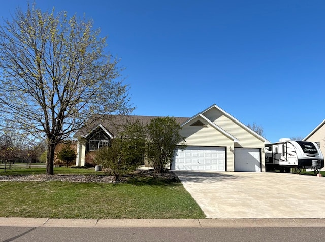 view of front of home with concrete driveway, an attached garage, and a front yard