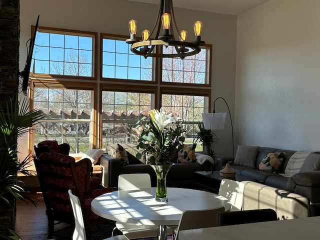 living area featuring a high ceiling, an inviting chandelier, and wood finished floors